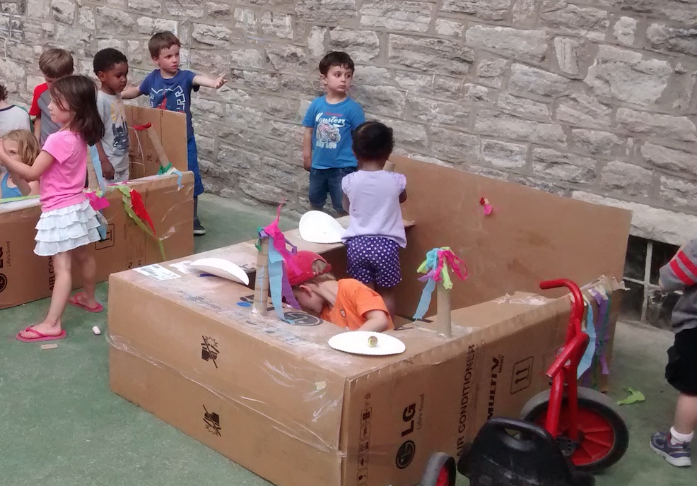 children decorate and build with cardboard boxes